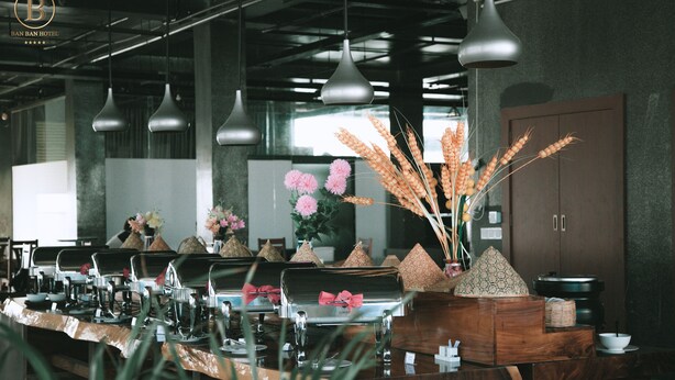 A hotel reception area with a long counter, metal chairs, and a large wooden cabinet. - Ban Ban Hotel (Phnom Penh)