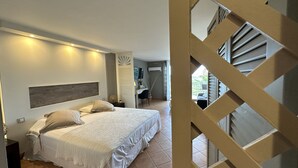 A bedroom with a large bed, a desk, and a TV. There is a balcony with a view of the outside. - Caribbean Escape - View Orient Bay and St Barth, pool and beach - 4217 (Orient Bay)