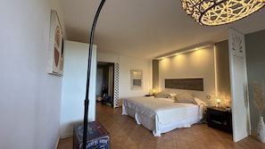A bedroom with two beds, a large mirror, and a decorative light fixture.