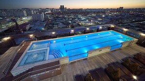 A rooftop swimming pool with a view of a cityscape at dusk. - Gwangju H1 Hotel (Gwangju)