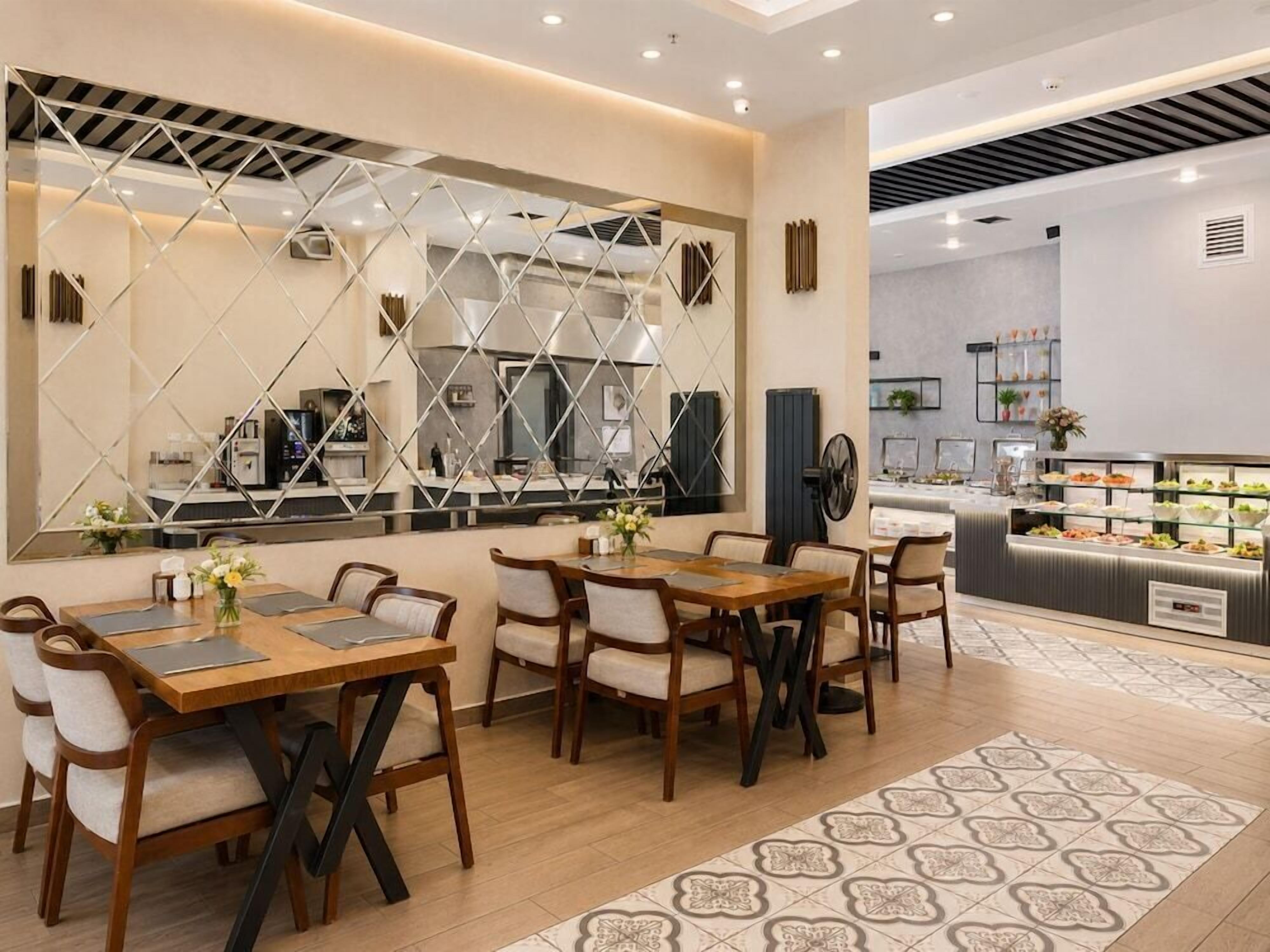 Un comedor con una mesa larga y sillas, un muro decorativo y un mostrador de buffet al fondo.
