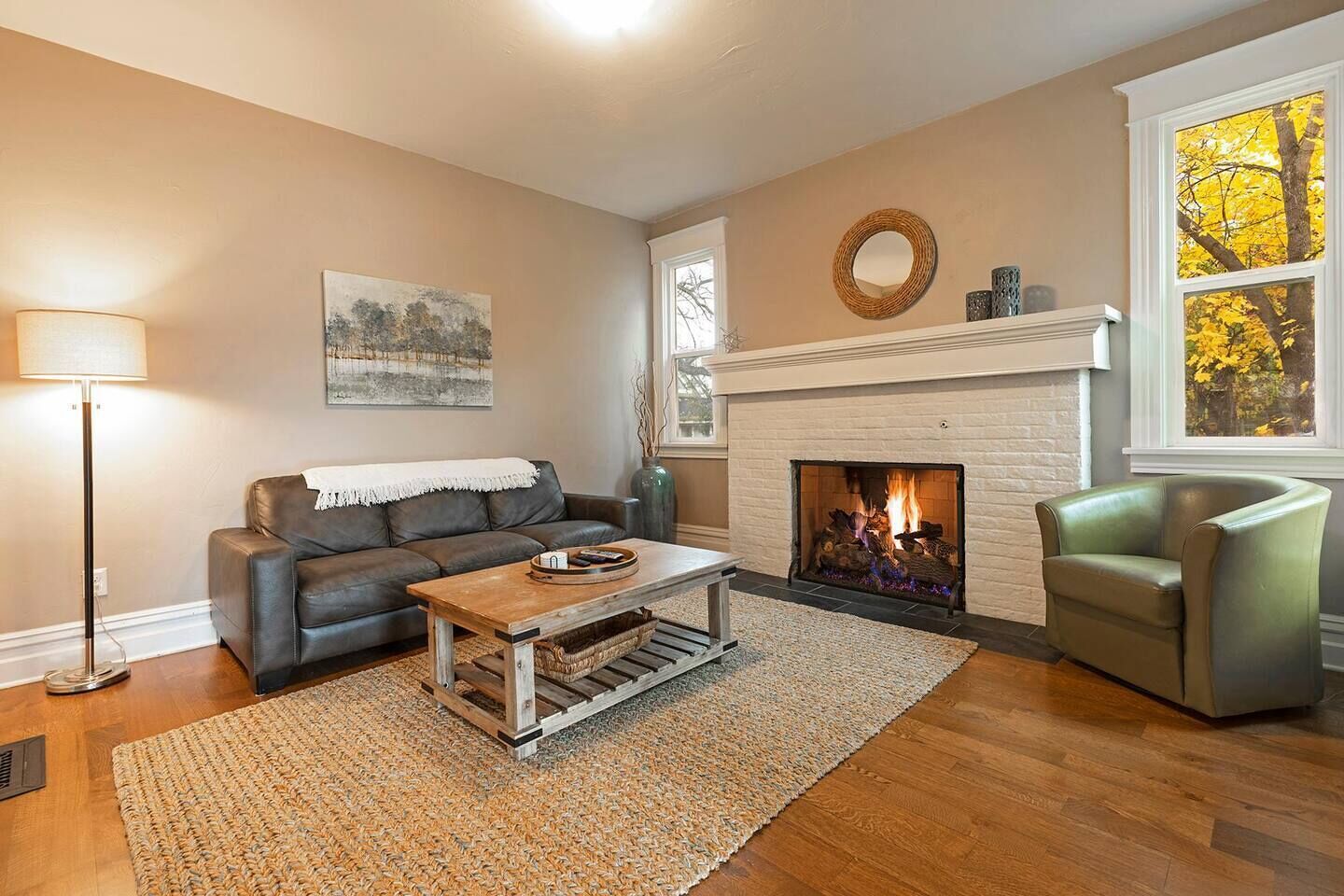A living room with a fireplace, a sofa, a coffee table, and a lamp.