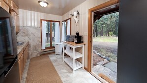 A kitchen with a stone backsplash, wooden cabinets, a built-in oven, and a window with curtains. - Three Pet Friendly cabins on 3.5 Acres -  Hot Tub/Views - 14 minutes to Purg (Durango)