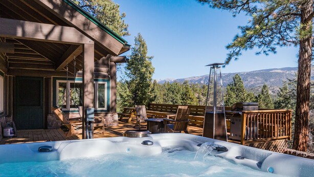A hot tub area with a wooden deck, outdoor seating, and a mountain view. - Three Pet Friendly cabins on 3.5 Acres -  Hot Tub/Views - 14 minutes to Purg (Durango)