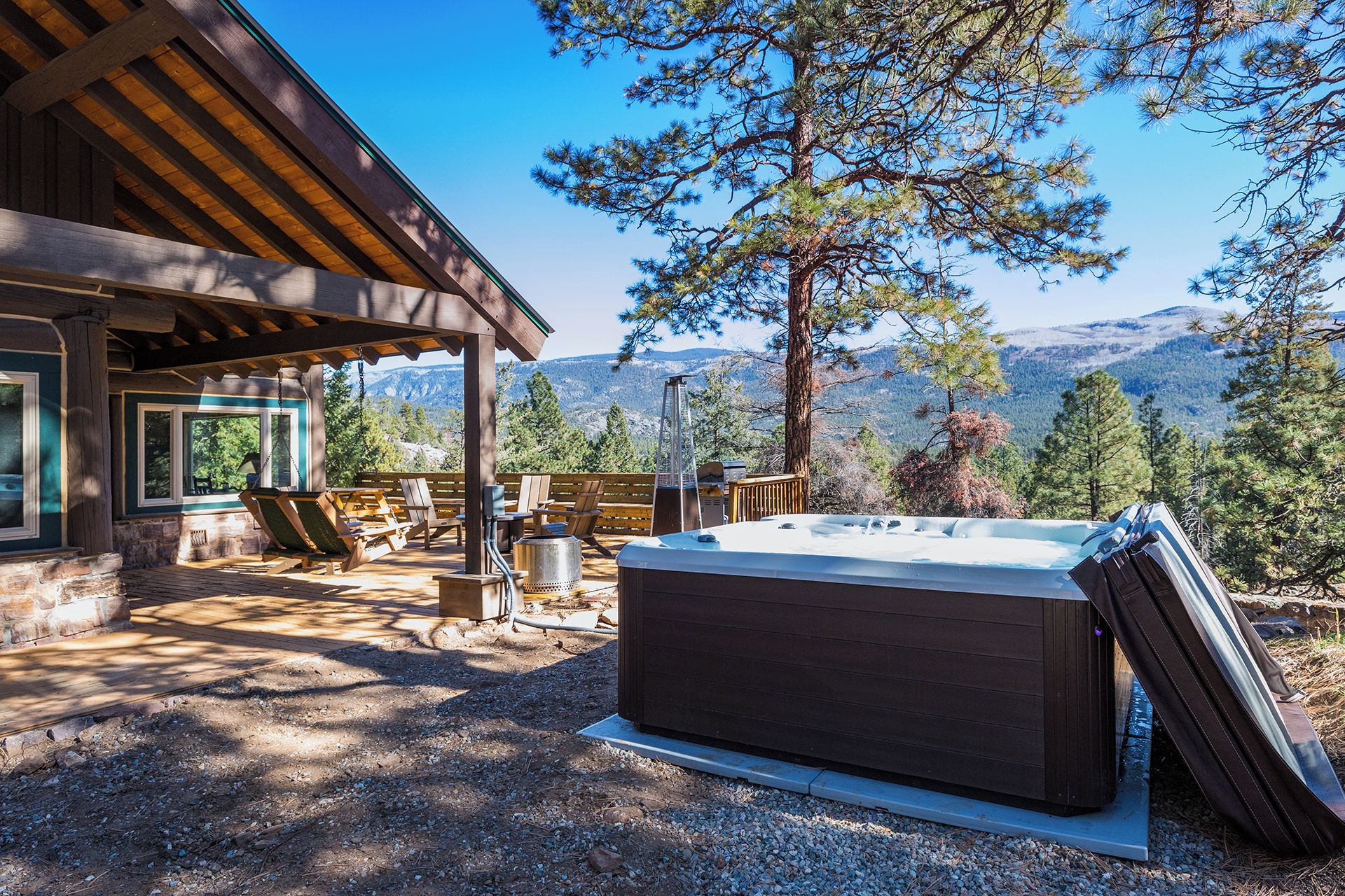 A hot tub in a covered outdoor area with a view of mountains.
