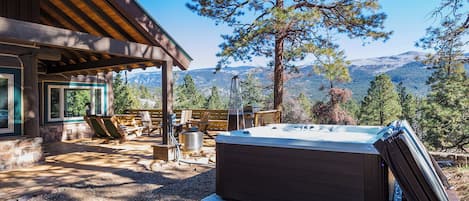 A hot tub in a covered outdoor area with a view of mountains.