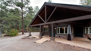 A rustic lodge with a covered porch, stone walls, and a gravel driveway. - Three Pet Friendly cabins on 3.5 Acres -  Hot Tub/Views - 14 minutes to Purg (Durango)