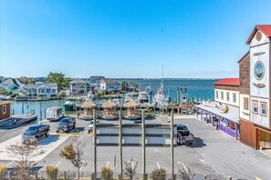 Stunning marina with sailboats and motorboats docked, surrounded by adjacent buildings and a parking area.