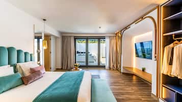 A modern hotel room with a large bed, a bench, a TV, and a wardrobe.
