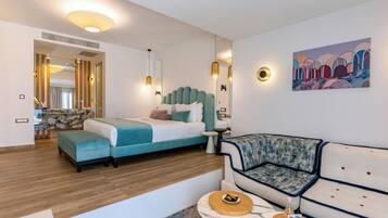 Ein modernes Hotelzimmer mit Bett, einer Couch, einem kleinen Tisch und einem Bild an der Wand.