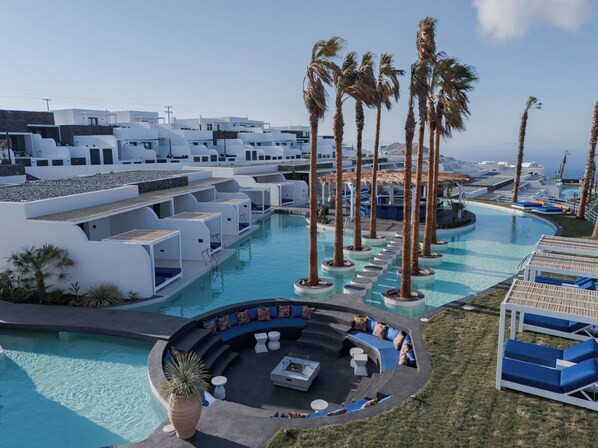 A modern resort with a pool, lounge areas, and palm trees.