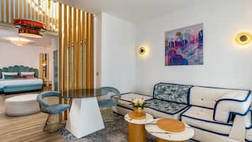 A modern living room with a sofa, chairs, a coffee table, and a dining table.