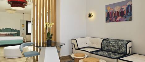 Un salon moderne avec une table basse en verre, un canapé et un coin repas doté d’une table ronde.