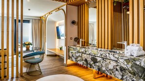 A modern bathroom with a marble vanity, wooden paneling, and a large mirror. - Cresanto Luxury Suites  (Santorini)