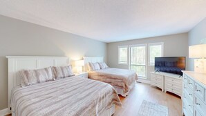 A bedroom with two beds, a TV, and a dresser. - Stunning, coastal chic two bedroom, two bathroom villa in Palmetto Dunes!! (Hilton Head)
