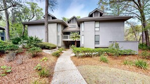 A two-story house with a covered front porch and a small deck. - Stunning, coastal chic two bedroom, two bathroom villa in Palmetto Dunes!! (Hilton Head)