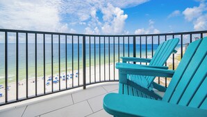 A balcony with a view of the beach and ocean.
