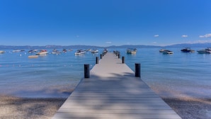 Un muelle de madera que se adentra en aguas tranquilas, con barcos amarrados a ambos lados.