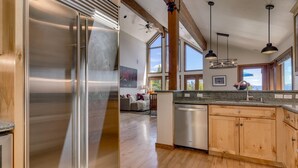 A modern kitchen with a stainless steel refrigerator, wooden cabinets, and a dishwasher. - Sierra Vista - Lakeview - TLUXP (Tahoe City)