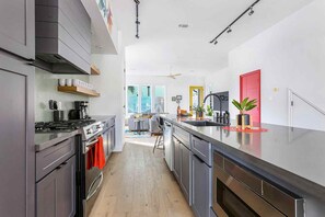 A modern kitchen with a central island, stainless steel appliances, and a bright, open layout.