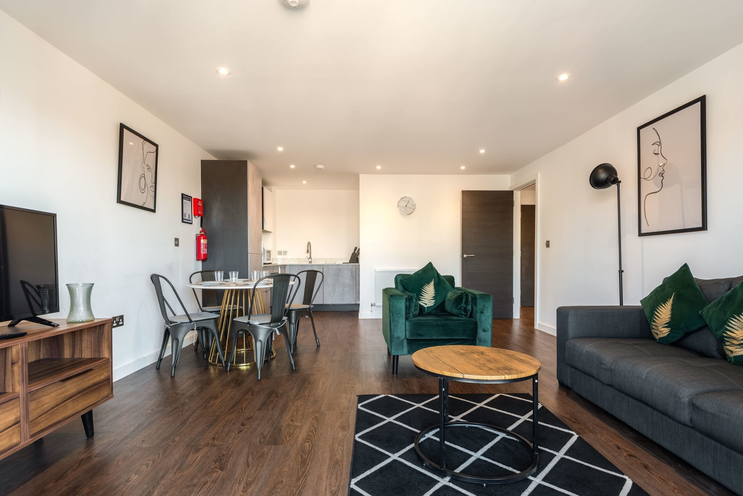 A modern living room with a sofa, a coffee table, and a dining area with chairs and a table.