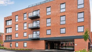A multi-story brick building with a flat roof, large windows, and a covered entrance. - Stay Zeni – Contemporary 2 BR Flat in York, Ouse Court (York)