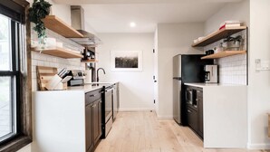 Una cocina moderna con armarios de madera, una isla central y electrodomésticos integrados.