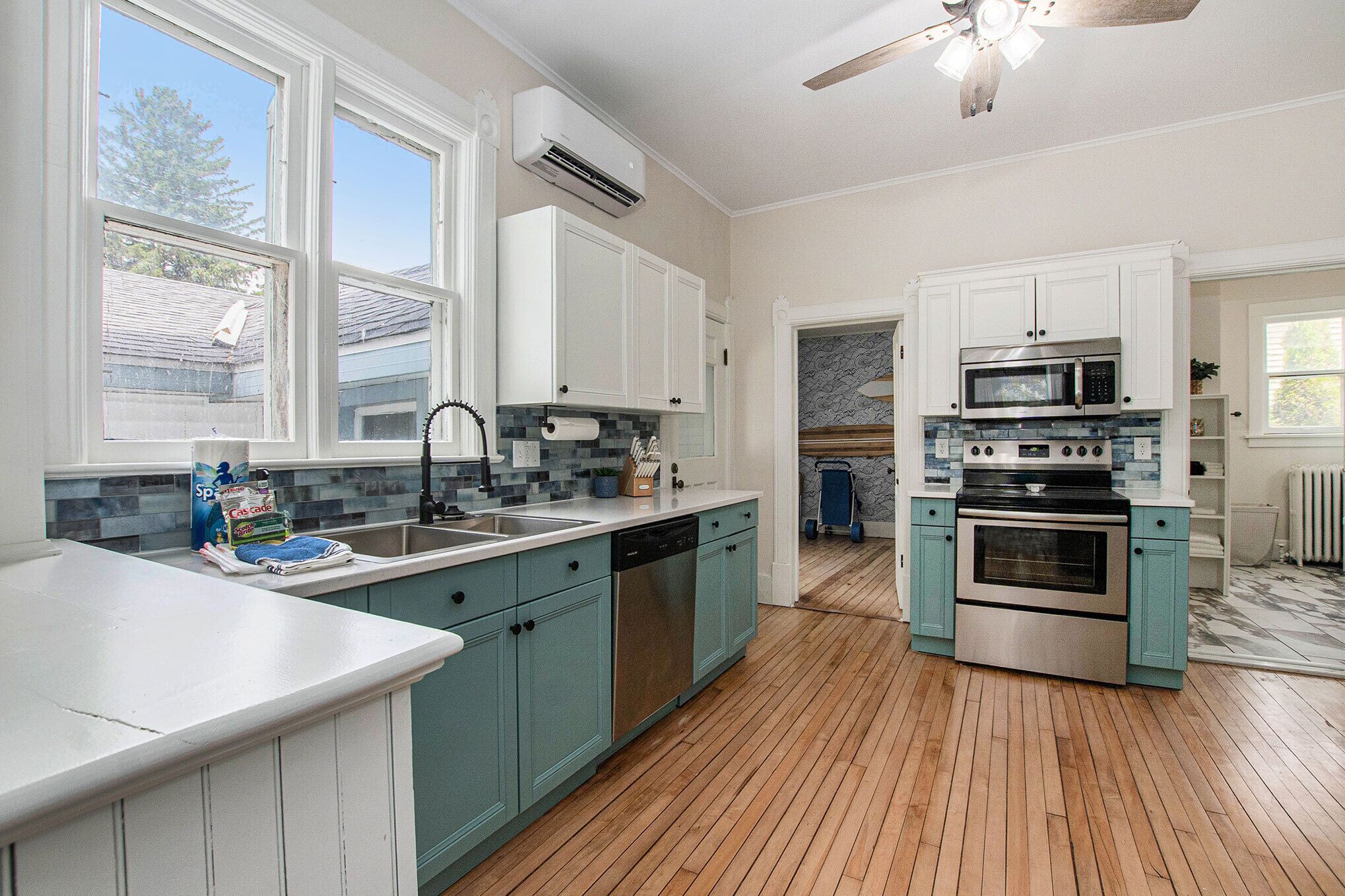 A kitchen with white cabinets, a stainless steel oven, a microwave, and a dishwasher.