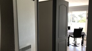 Een kamer met een schuifdeur die leidt naar een eetruimte met een tafel en stoelen.