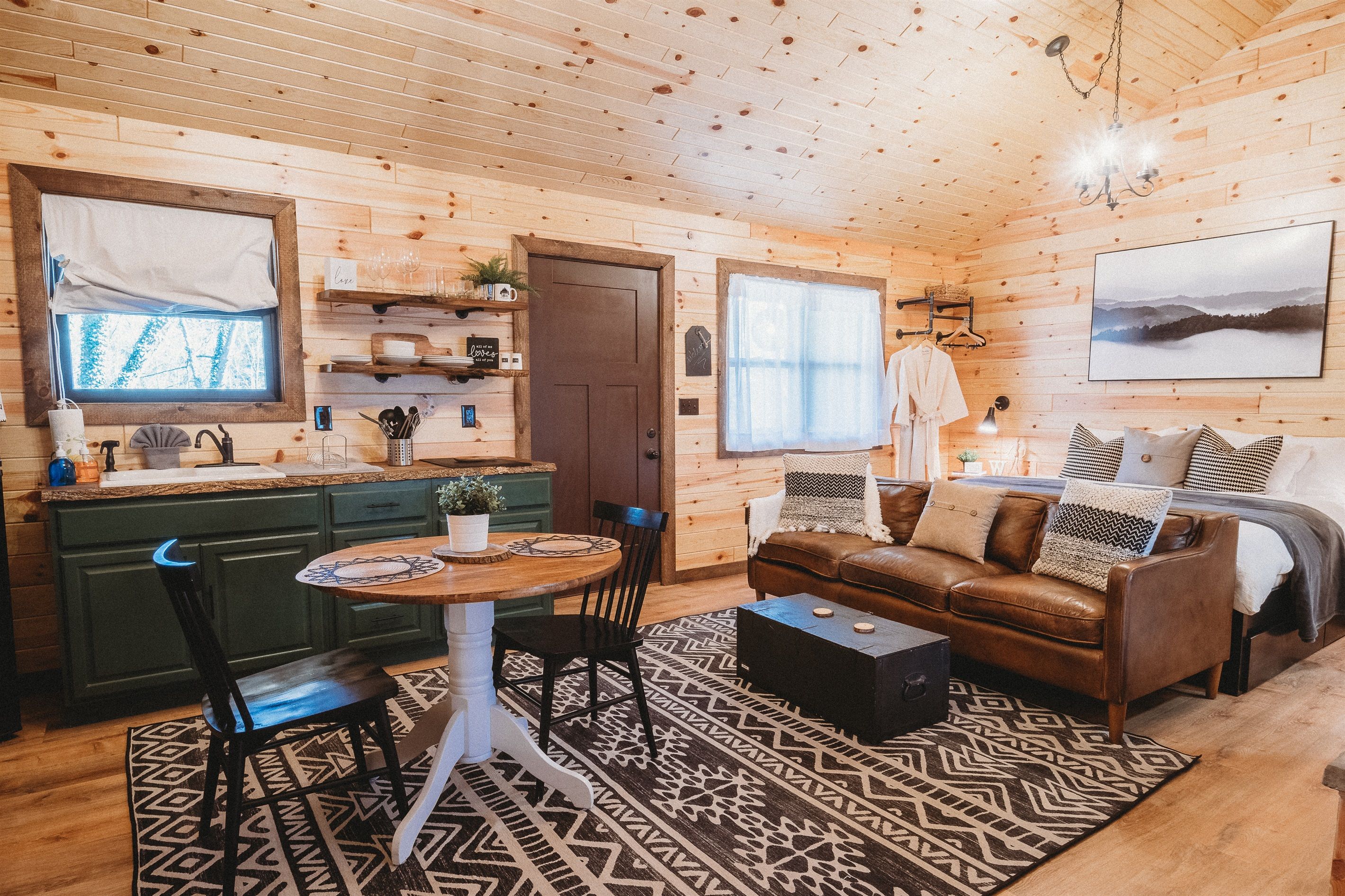 Un intérieur de chalet chaleureux comprenant un coin repas, une cuisine et un salon.