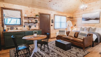 Un intérieur de chalet chaleureux comprenant un coin repas, une cuisine et un salon.