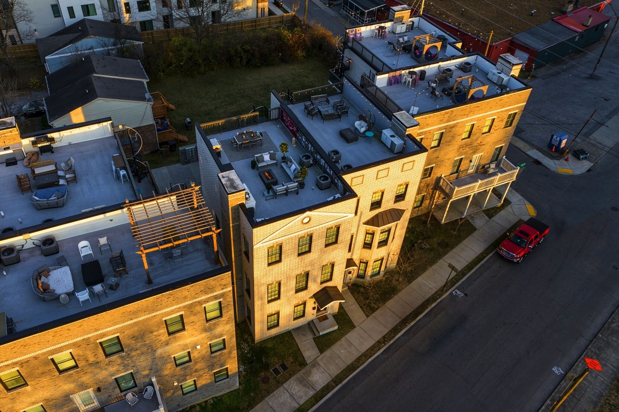 A multi-story building with a rooftop patio area, a fire escape, and a street view.