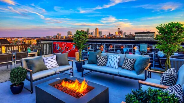 A rooftop terrace with a fire pit, seating area, and a city skyline view. - Walk2Germantown Rooftop Firepit Downtown Skyline King Suite 2-Car Garage (Nashville)