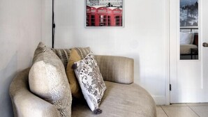 A living room with a beige sofa, patterned cushions, a floor lamp, and a framed picture of a red building. - 313 Room with a view 1 block from the beach (Fort Lauderdale)
