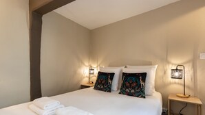 Ein Hotelzimmer mit einem Bett, zwei Nachttischen und einer Lampe.