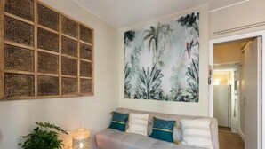 Ein Wohnzimmer mit einer Couch, einem großen Wandbild und einer Dekorationstafel.