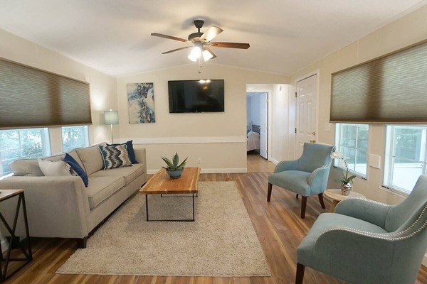 Flat screen Roku television with sofa, coffee table, chairs