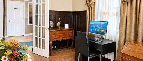 Habitación de hotel con escritorio, computadora y vista al lago.