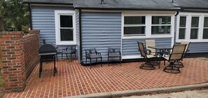 Relax in a patio area with outdoor furniture and a grill, perfect for leisure and outdoor activities.