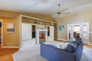 A living room with a fireplace, a ceiling fan, and a sign reading "LAKE HAVASU ARIZONA" on the wall. - Rhythms of Tom Tom Sparkling Pool (Lake Havasu City)