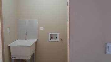 Un baño pequeño con un lavamanos blanco, un espejo y una lámpara en el techo.