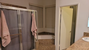 A bathroom with a shower, a bathtub, a sink, and a toilet. - Loving life! (Indian Wells)