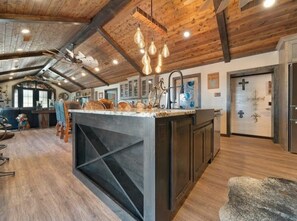 Enjoy cooking in this well-equipped kitchen with a large island, cabinet, and modern sink.