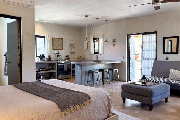 Un intérieur moderne comprenant un lit, un canapé, un coin repas et une cuisine.