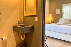 Une salle de bain avec un lavabo intégré, un miroir et des toilettes.