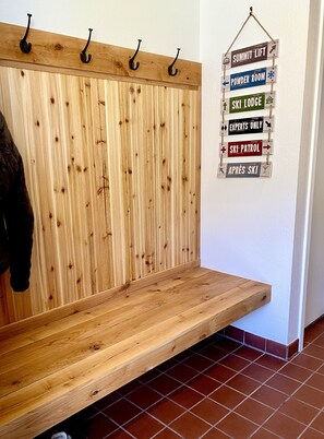 A wooden bench with a slatted backrest and a wall-mounted sign with directional arrows. - Short Walk to Slopes, Great Views, Shared Hot Tub (Frisco)