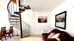 A living room with a spiral staircase, a sofa, a rug, and two framed pictures on the wall. - 3 min Walk to Slopes, Great Views, Shared Hot Tub  (Frisco)