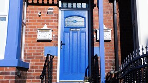 A blue door with a white mailbox and a small potted plant on the step. - Modern 1-Bed Apartment – 3 Min Walk to HOST & Pitman, Leeds (Leeds)