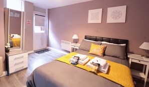 Ein Hotelzimmer mit Bett, Nachttischen, einem Spiegel und Bildern an der Wand.