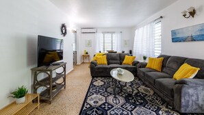 Ein Wohnzimmer mit Fernseher, Sofa und Couchtisch.